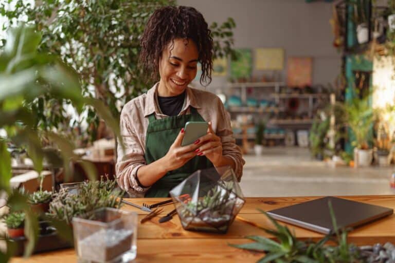 femme fleuriste utilisant les réseaux sociaux avec sourire